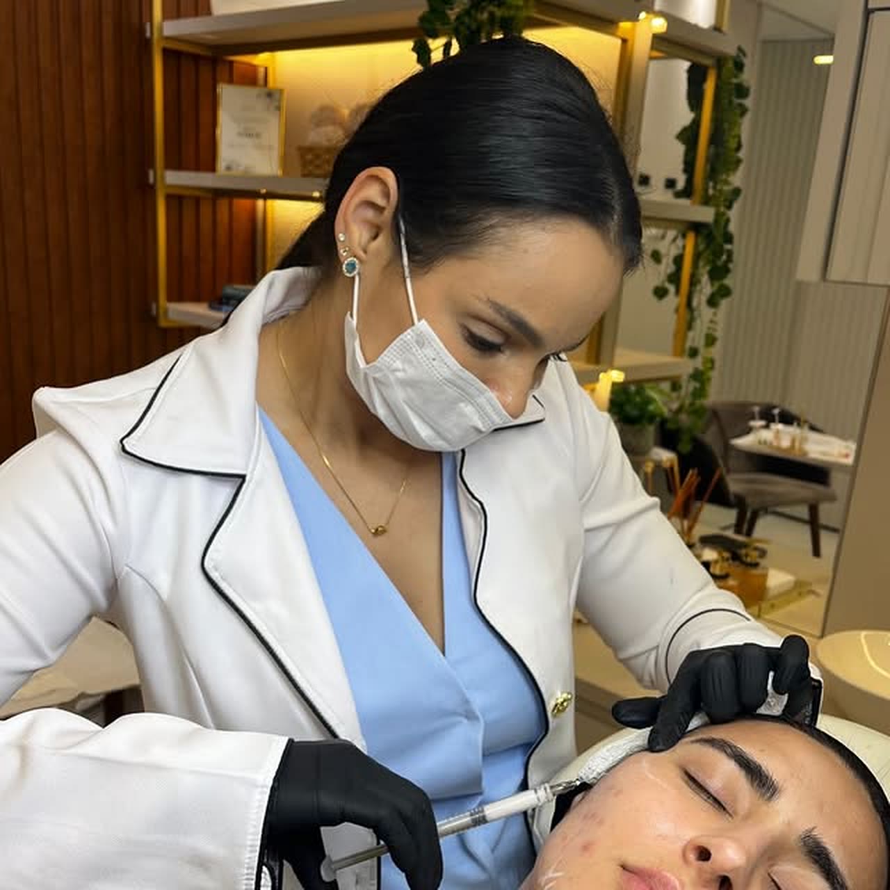 Dra. Lorrainy Caroline realizando um procedimento facial na clínica.